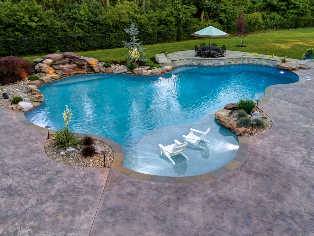 Two chairs submerged into large backyard pool