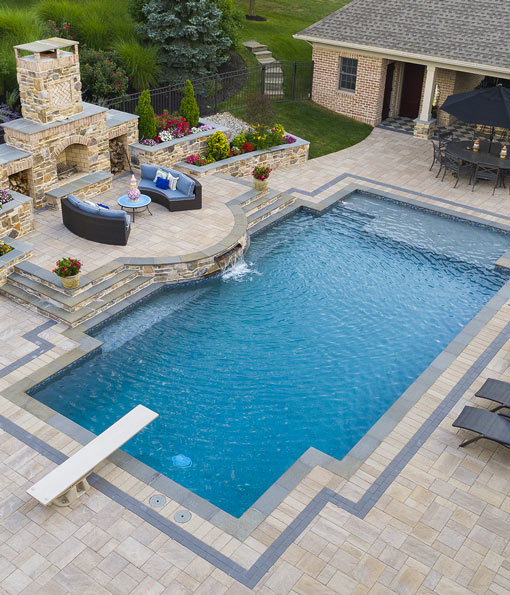 Luxury backyard pool with sitting area and fire place