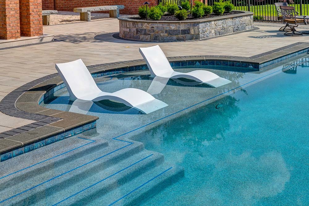 Two modern lounge chairs nested in pool