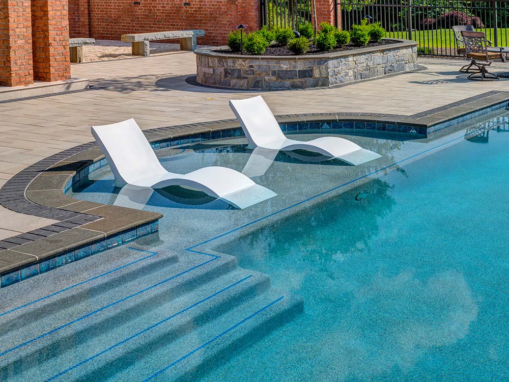 Two modern lounge chairs nested in pool